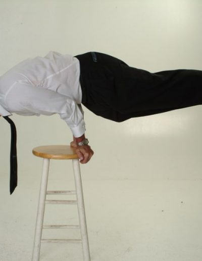 Image of Christopher Saam balancing horizontally on a stool